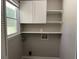 Functional laundry room with storage cabinets and a window, ideal for organization at 6512 Executive Dr, Winston, GA 30187