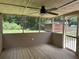 Spacious screened porch featuring a ceiling fan and views of the lush backyard and storage shed at 6512 Executive Dr, Winston, GA 30187