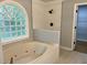 Bright bathroom featuring a large tub beneath a window and a separate tiled shower area at 730 Redlion Run, Alpharetta, GA 30022