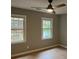 Bedroom featuring hardwood floors, two windows, and a ceiling fan with light at 730 Redlion Run, Alpharetta, GA 30022