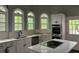 Kitchen featuring a central island, white cabinets, arched windows, and stainless steel appliances at 730 Redlion Run, Alpharetta, GA 30022