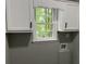 Bright laundry room featuring white cabinets, a window, and modern fixtures at 730 Redlion Run, Alpharetta, GA 30022