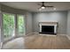 Living room featuring hardwood floors, a cozy fireplace and large windows at 730 Redlion Run, Alpharetta, GA 30022