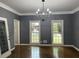 Living room featuring hardwood floors, gray walls, two windows, and a modern chandelier at 730 Redlion Run, Alpharetta, GA 30022