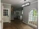 Open living room area with hardwood floors, a staircase, kitchen view, arched window, and stylish light fixture at 730 Redlion Run, Alpharetta, GA 30022
