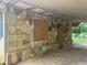 Stone-accented carport features textured stone siding and boarded-up windows at 1692 Pheasant Dr, Jonesboro, GA 30238