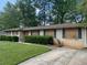 Ranch-style home with brick facade, mature landscaping, and boarded-up windows at 1692 Pheasant Dr, Jonesboro, GA 30238