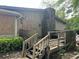 Rustic deck and stone chimney of a home with boarded windows at 1692 Pheasant Dr, Jonesboro, GA 30238
