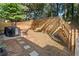 Landscaped backyard featuring a patio area, a fire pit, with a wooden fence and retaining wall at 2040 Harvest Ridge Cir, Buford, GA 30519
