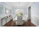Bright dining room features a modern chandelier, wainscotting, and wood floors at 2040 Harvest Ridge Cir, Buford, GA 30519