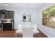 Dining area with a modern white table, stylish chandelier, and hardwood floors at 2040 Harvest Ridge Cir, Buford, GA 30519
