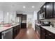 Modern kitchen featuring stainless steel appliances, granite countertops, and dark wood cabinets at 2040 Harvest Ridge Cir, Buford, GA 30519