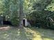 Backyard view featuring a storage shed surrounded by mature trees, and well-maintained lawn at 2317 Wilkins Ct, Decatur, GA 30035