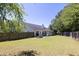 Large backyard featuring lush green space, a fenced perimeter, and a cozy patio area at 2780 Matlin Way, Buford, GA 30519