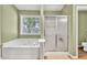 Bathroom features a soaking tub, a shower, and a window with natural light at 2780 Matlin Way, Buford, GA 30519