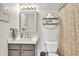 Bathroom features a white vanity, decorative mirror and convenient open shelving at 2780 Matlin Way, Buford, GA 30519