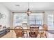 Warm dining room features a large window, ample natural light, and stylish wooden dining set at 2780 Matlin Way, Buford, GA 30519