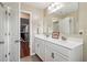 Bright bathroom featuring a double sink vanity with white cabinets, and a large mirror at 776 Amos Ln, Kennesaw, GA 30152