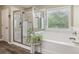The bright bathroom showcases a tub, glass shower, tile floors, and natural light at 776 Amos Ln, Kennesaw, GA 30152