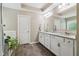 A spacious bathroom featuring double sinks with granite counters, tile floors, and white cabinets at 776 Amos Ln, Kennesaw, GA 30152