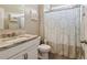 Neutral bathroom featuring a tub with patterned shower curtain, granite vanity and ample storage at 776 Amos Ln, Kennesaw, GA 30152