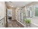 This bathroom features a modern glass enclosed shower and separate soaking tub with tile flooring at 776 Amos Ln, Kennesaw, GA 30152