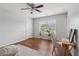 Bright bedroom featuring hardwood floors, a ceiling fan, and natural light from the large window at 776 Amos Ln, Kennesaw, GA 30152