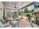 Inviting covered patio with a stone fireplace, comfortable seating, and an outdoor kitchen area at 776 Amos Ln, Kennesaw, GA 30152