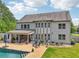 Back of the house featuring a two-story design, multiple windows, covered patio, swimming pool, and landscaped backyard at 776 Amos Ln, Kennesaw, GA 30152