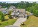 Aerial view of a two-story stone house with a well-manicured lawn, landscaping, and three-car garage at 776 Amos Ln, Kennesaw, GA 30152