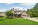 Beautiful two-story stone home with a well-manicured lawn and covered front porch seating at 776 Amos Ln, Kennesaw, GA 30152