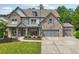 Stately two-story home with a stone facade, covered porch, three-car garage and lush landscaping at 776 Amos Ln, Kennesaw, GA 30152