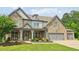 Attractive two-story home featuring a stone facade, covered porch and mature landscaping at 776 Amos Ln, Kennesaw, GA 30152