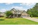 Beautiful stone-front home with a manicured lawn, mature trees and a three-car garage at 776 Amos Ln, Kennesaw, GA 30152