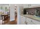 Kitchen features gray subway tile backsplash, white cabinets, and granite counters that open to the adjacent living room at 776 Amos Ln, Kennesaw, GA 30152