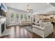 Bright living room with hardwood floors, fireplace, large windows and furniture, open to a modern kitchen at 776 Amos Ln, Kennesaw, GA 30152