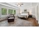 An airy main bedroom with tray ceiling, ample windows, a leather chair, and area rug at 776 Amos Ln, Kennesaw, GA 30152