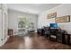 A tidy home office featuring hardwood floors, a desk, and a bird cage by the window at 776 Amos Ln, Kennesaw, GA 30152