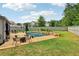 Backyard pool with concrete patio and seating area, fenced in yard, and lush green landscaping at 776 Amos Ln, Kennesaw, GA 30152