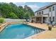 Beautiful in-ground pool with a spacious patio, lush landscaping, and a covered outdoor living area at 776 Amos Ln, Kennesaw, GA 30152