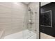 Modern bathroom featuring tiled walls, a sleek bathtub, and stylish glass shower screen at 860 Peachtree Ne St # 2801, Atlanta, GA 30308