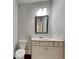Powder room features a white vanity, modern faucet, and decorative framed mirror at 9866 Garden Hill Ln, Douglasville, GA 30135