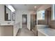 Well-lit bathroom features double vanity sinks, a glass shower, and soaking tub at 9866 Garden Hill Ln, Douglasville, GA 30135