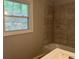 Bathroom featuring tile walls, a window, tub, and white sink at 172 Camp Sunrise Nw Rd, Cartersville, GA 30121