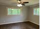 Bedroom with dark hardwood floors, neutral walls, white trim, ceiling fan with lighting, and large windows at 172 Camp Sunrise Nw Rd, Cartersville, GA 30121