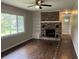 Living room features wood floors, a brick fireplace with a built-in shelving, and a window at 172 Camp Sunrise Nw Rd, Cartersville, GA 30121