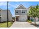Charming townhome featuring gray siding, brick accents, and an attached one car garage and driveway at 1884 Plainsboro Dr, Lithonia, GA 30058