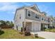 Townhome with gray siding and brick accents, featuring a well-maintained lawn and an attached one car garage at 1884 Plainsboro Dr, Lithonia, GA 30058