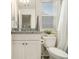 Well-lit bathroom featuring a vanity, toilet, and window with natural light at 1884 Plainsboro Drive Dr, Lithonia, GA 30058