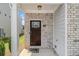 Close-up of the front door, showcasing brick accents, a welcome mat, and a charming entrance at 1884 Plainsboro Drive Dr, Lithonia, GA 30058